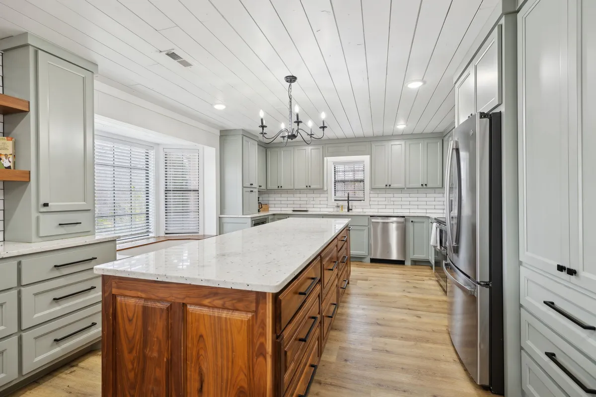 The fully equipped kitchen is showcased here, centered around a large island with ample workspace, stylish light fixtures, and modern cabinetry. The layout is ideal for prepping meals, hosting cooking lessons, or enjoying group culinary adventures.